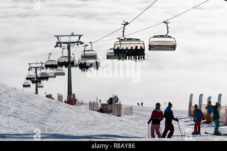 Feldberg im Schwarzwald, Deutschland. 15 Dez, 2018. Skifahrer Fahrt unter einem Sessellift über dem Meer der Wolken. Die ersten Aufzüge auf dem Feldberg im Schwarzwald eröffnet. Quelle: Patrick Seeger/dpa/Alamy leben Nachrichten Stockfoto