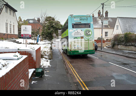 Englisches Dorf Auftauen nach Schnee mit Double Decker Bus in Bewegung vorbei an verschneiten Häuser, Totland Bay, Isle of Wight, Großbritannien Stockfoto