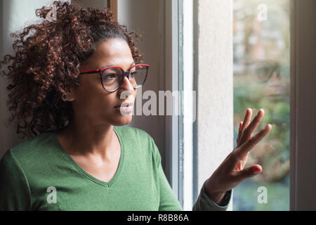 Traurig afrikanische amerikanische Mädchen schauen aus dem Fenster
