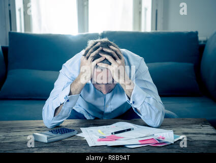 Besorgt und verzweifelten Unternehmer junger Mann Berechnung Rechnungen Steuern und Finanzen zählen Unternehmen oder zu Hause auf der Couch zu Hause sitzen in Zahlen Stockfoto