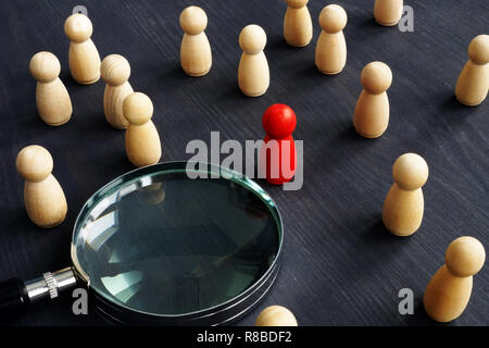 Holzfiguren und Lupe. Personalauswahl Konzept. Die Einstellung der Mitarbeiter zu arbeiten. Stockfoto