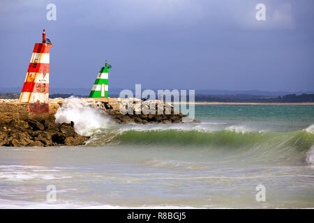 Die Wellen auf den Strand vor Der lred & Grün ighthouses in Lagos, Portugal zu brechen. Stockfoto