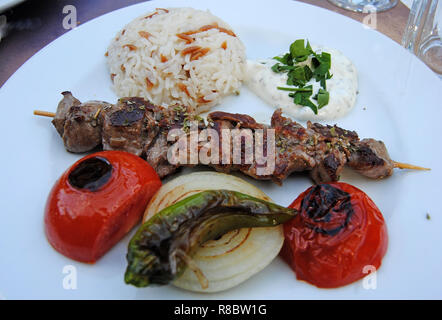 Platte von Shish Kebab (kuzu shish) mit Reis, Tomaten und Paprika. Stockfoto