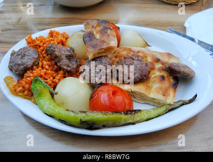 Gegrilltes Fleisch türkischen Kugeln (izgara Köfte), mit Brot, gegrillten Tomaten und Paprika. Stockfoto