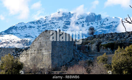 Außenwand des antiken Amphitheater in Selge, Türkei, mit schneebedeckten Gipfel des Mt Bozburun (2504 m) im Hintergrund. Stockfoto