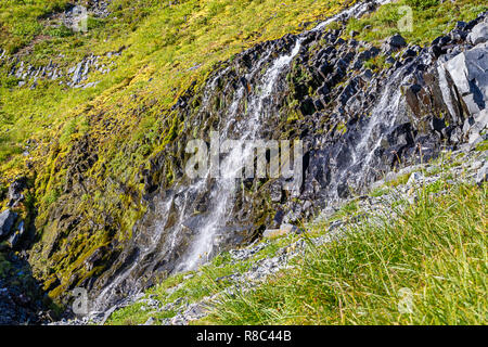 Kleiner Bach über Felsen und die Erde in eine Almwiese Stockfoto