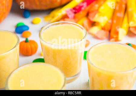 Detailansicht der Smoothie in Glas mit Süßigkeiten auf Hintergrund in weißer Tisch Stockfoto