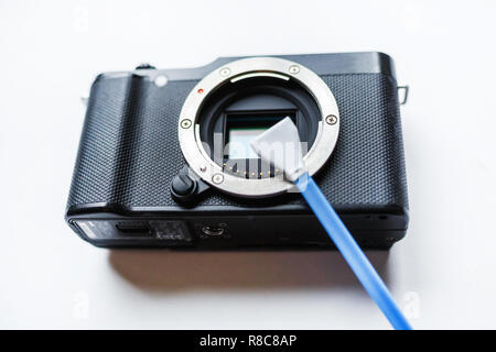 Nahaufnahme der spiegellosen digitale APS-C-Sensor verschmutzt Kamera matrix Reinigung und Wartung mit Tupfer, Fotograf Reinigung Photocamera auf weißem backgro Stockfoto