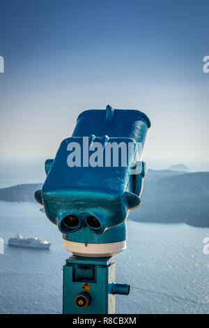 Blaue Fernglas und Cruiseship im Sommer auf der Insel Santorini in Griechenland. Ferngläser, Aussicht, Kreuzfahrt, Sommer, Urlaub, Luxus reisen Konzepte. Stockfoto