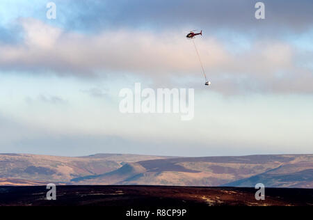 Hubschrauber Bewegen schwerer Rock Platten für Fußweg Erosion Kontrolle über Alport Moor im Derbyshire Peak District Stockfoto