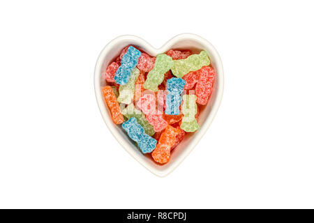 Verschiedene Farbe süß-saure Bonbons oder Zucker junk food in Herzform Schüssel isoliert auf Weiss mit Freistellungspfad in allen Größen. Stockfoto