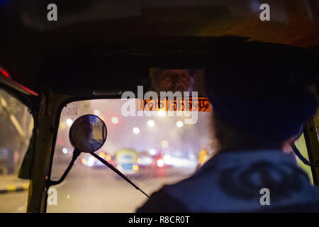 Eine Auto-rikscha Fahrer fahren in den Straßen von New Delhi in der Nacht. Indien. Stockfoto