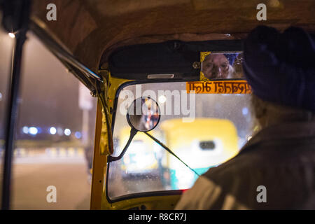 Eine Auto-rikscha Fahrer fahren in den Straßen von New Delhi in der Nacht. Indien. Stockfoto