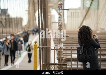 Ein Tourist ist unter Foto aus der berühmten Brooklyn Bridge in Manhattan, New York, United States. Stockfoto