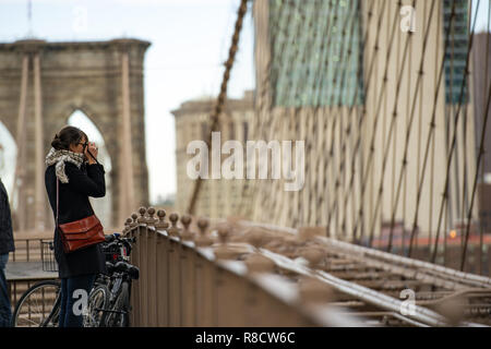 Ein Tourist ist unter Foto aus der berühmten Brooklyn Bridge in Manhattan, New York, United States. Stockfoto