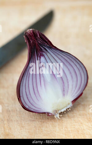 Rote Zwiebel halbe mit Messer auf einer hölzernen Schneidebrett Stockfoto