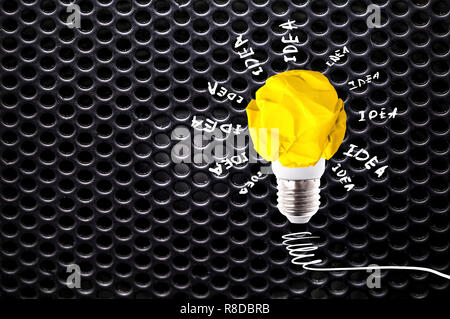 Zerknittertes Papier gelb Glühbirne mit Beschriftung Idee auf dunklen grauen Kreis mesh Pattern Stockfoto