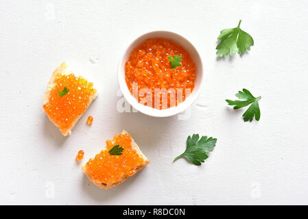 Sandwiches mit rotem Kaviar am weißen Stein Hintergrund. Ansicht von oben, flach Stockfoto