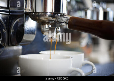 Entspannen Sie sich, während Sie ihr Getränk bereit ist. Kaffeetassen. Kleine Tassen Kaffee Getränke zu servieren. Kaffee im Kaffeehaus oder Cafe gebraut. Kaffee brühen mit Espressomaschine. Espresso mit portafilter Stockfoto