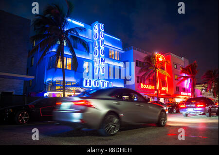 MIAMI - Januar 08, 2018: Autos fahren an iconic Die bunten Leuchtreklamen Art-déco-Hotels am Ocean Drive in South Beach bei Nacht. Stockfoto