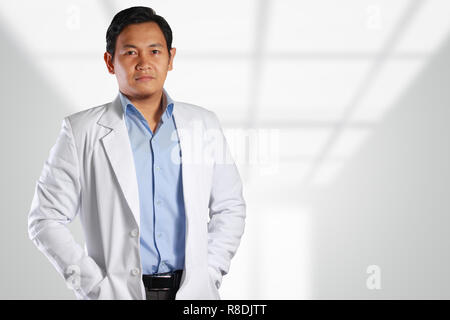 Foto Bild eines stattlichen, attraktiven, selbstbewussten, erfolgreichen jungen asiatischen männlicher Arzt lächelnd auf der Vorderseite mit verschwommen, unscharf Hintergrund Stockfoto