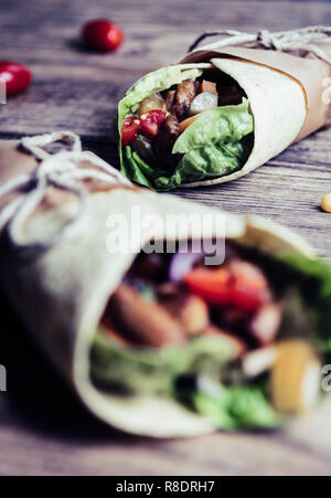 Traditionelle mexikanische Tortilla Wrap mit Gemüse und gegrilltem Hähnchenfleisch auf Holz Tisch Stockfoto