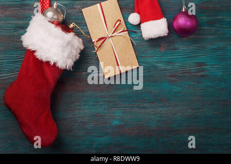 Weihnachten Socke, Umschlag und Dekoration über alte Holz- Hintergrund. Stockfoto