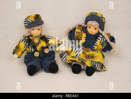 Zwei kleine Puppen mit gelb blau Kleidung und eine Kappe Stockfoto