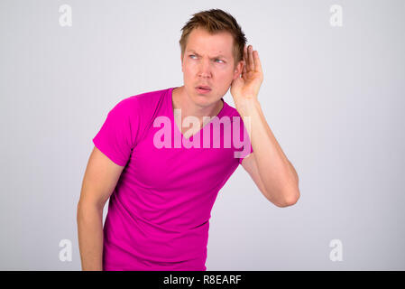Jungen gutaussehenden Mann denken, während Sie gegen den weißen Hintergrund Stockfoto