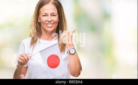 Mittleres Alter Hispanic woman holding Flagge von Japan über isolierte Hintergrund mit Lächeln tun ok Zeichen glücklich, Daumen hoch, mit den Fingern, ausgezeichnete Zeichen Stockfoto