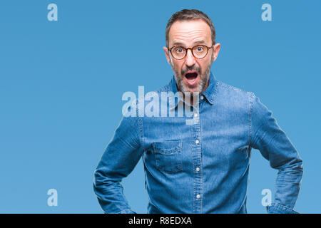 Mittleres Alter hoary älterer Mann mit Brille über isolierte Hintergrund lächelnd Seite suchen und sie starrte Denken. Stockfoto