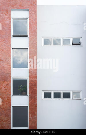 Moderne Vintage-Fenster mit weißen und roten Backsteinwänden Stockfoto