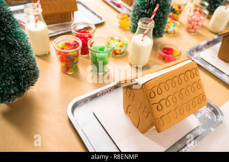 Kinder Partei kleine Lebkuchenhäuser mit Bonbons zu verzieren. Stockfoto