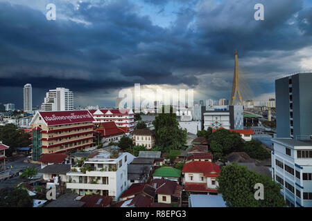 Dunkle Monsunwolken über Rama XIII. Brücke (rechts) und Wat Sam Phraya (links) in der Phra Nakhon von Bangkok, Thailand Stockfoto