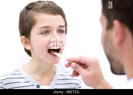 Arzt mit zungenspatel, Boy's Mund. Stockfoto