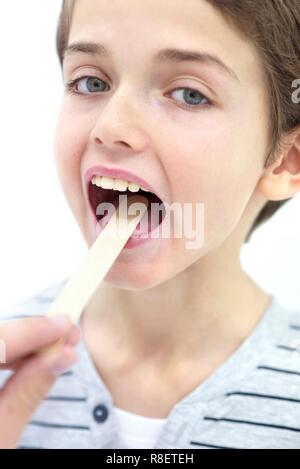 Junge mit Mund offen und zungenspatel. Stockfoto