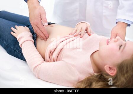 Der Arzt prüft Mädchen abdomen Stockfoto