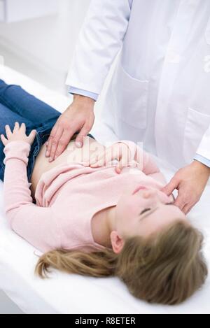 Der Arzt prüft Mädchen abdomen Stockfoto