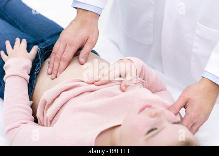 Der Arzt prüft Mädchen abdomen Stockfoto