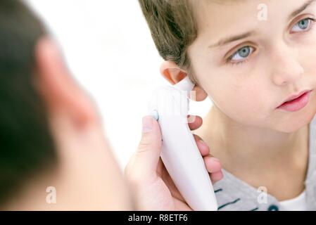 Junge in seiner Temperatur mit einem digitalen Thermometer genommen. Stockfoto