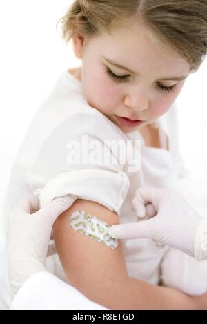 Arzt Pflaster auf den Arm junge Mädchen nach der Injektion Stockfoto