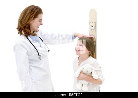 Ärztin messen junge Mädchen auf Höhe chart. Stockfoto