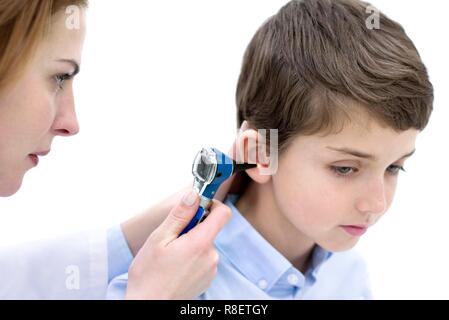 Der Arzt prüft junge Ohr mit einem Otoskop. Stockfoto