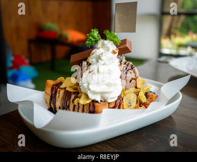 Honig santos Eis Dessert/Brot mit Schokolade Eis schaufeln Corn Flake Sahne Schokolade und Honig Biene auf weiße Platte im Cafe co Stockfoto