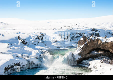 Wilde Wasser der Skjalfandafljot Fluss in den Godafoss Wasserfall fließt. Wirbelnde türkisfarbenes Wasser, Schnee gefrorene Landschaft, felsigen Vordergrund Stockfoto