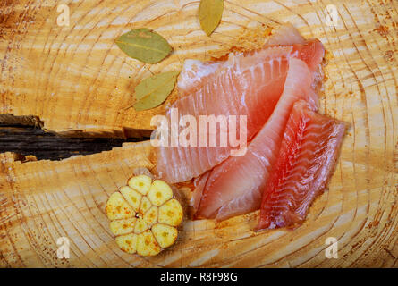 Frischer Fisch Filet tilapia mit Zutaten zum Kochen auf hölzernen Tisch Stockfoto