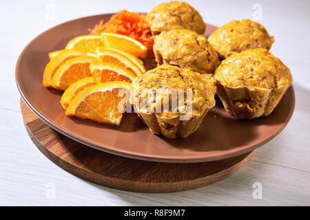 Carotte Muffins serviert auf der Platte mit Orangenscheiben. Stockfoto