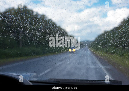 Regentropfen auf der Windschutzscheibe, die aus dem Inneren des Autos Stockfoto