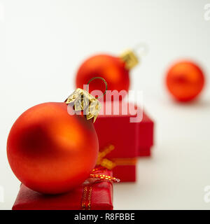 Festliche rote Kugeln und Boxen auf einem hellen Hintergrund. Weihnachten Komposition. Stockfoto