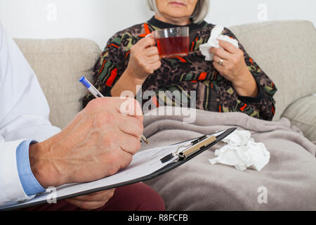 Doktor mit Zwischenablage Diagnose eines älteren Patienten zu Hause Stockfoto